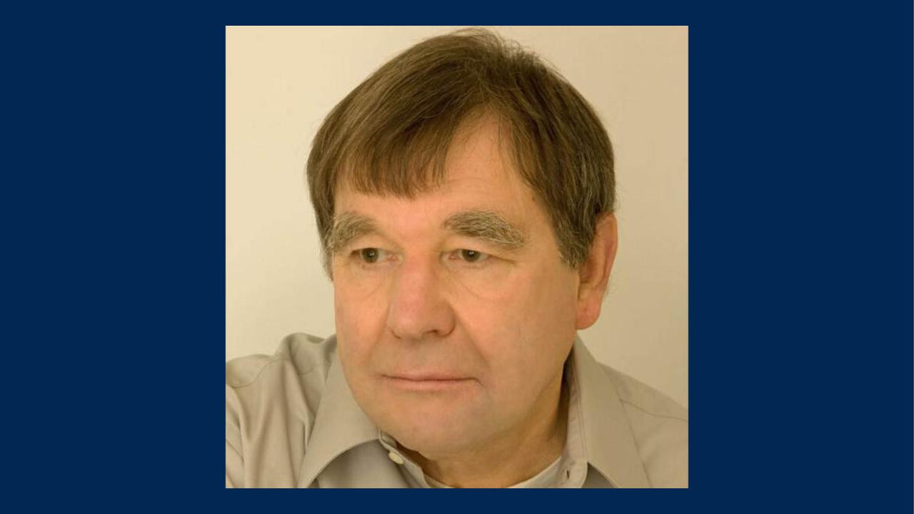 Head-and-shoulders portrait photograph of a middle-aged man with brown hair, neutral expression