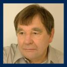 Head-and-shoulders portrait photograph of a middle-aged man with brown hair, neutral expression